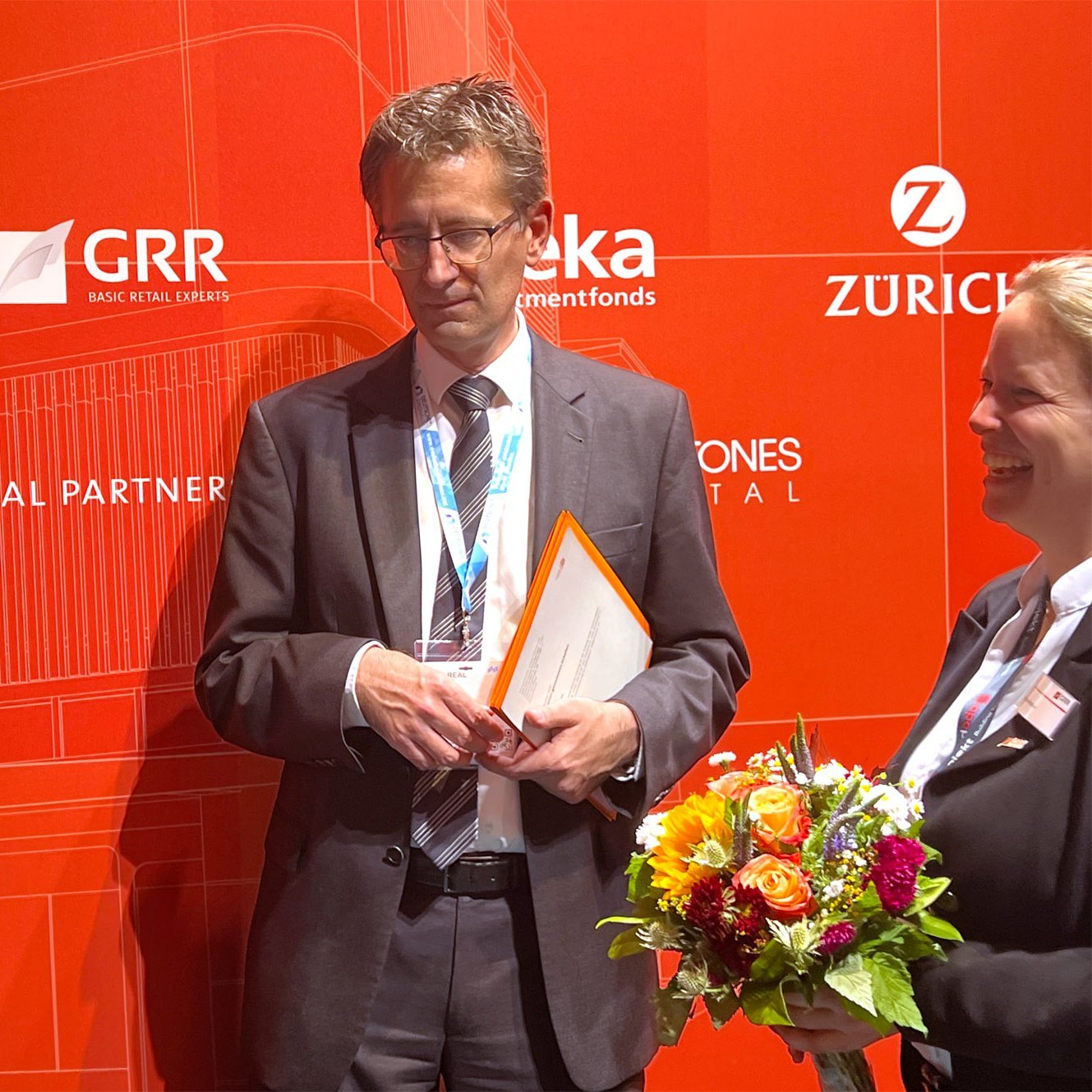 Marek Sacha, CEO BuildingMinds, Martin Führlein, CEO/Geschäftsführer GRR Group und Dr. Astrid Keller, ESG- und Research Managerin GRR Group, besiegeln die Zusammenarbeit von BuildingMinds und GRR Group auf der EXPO REAL in München.